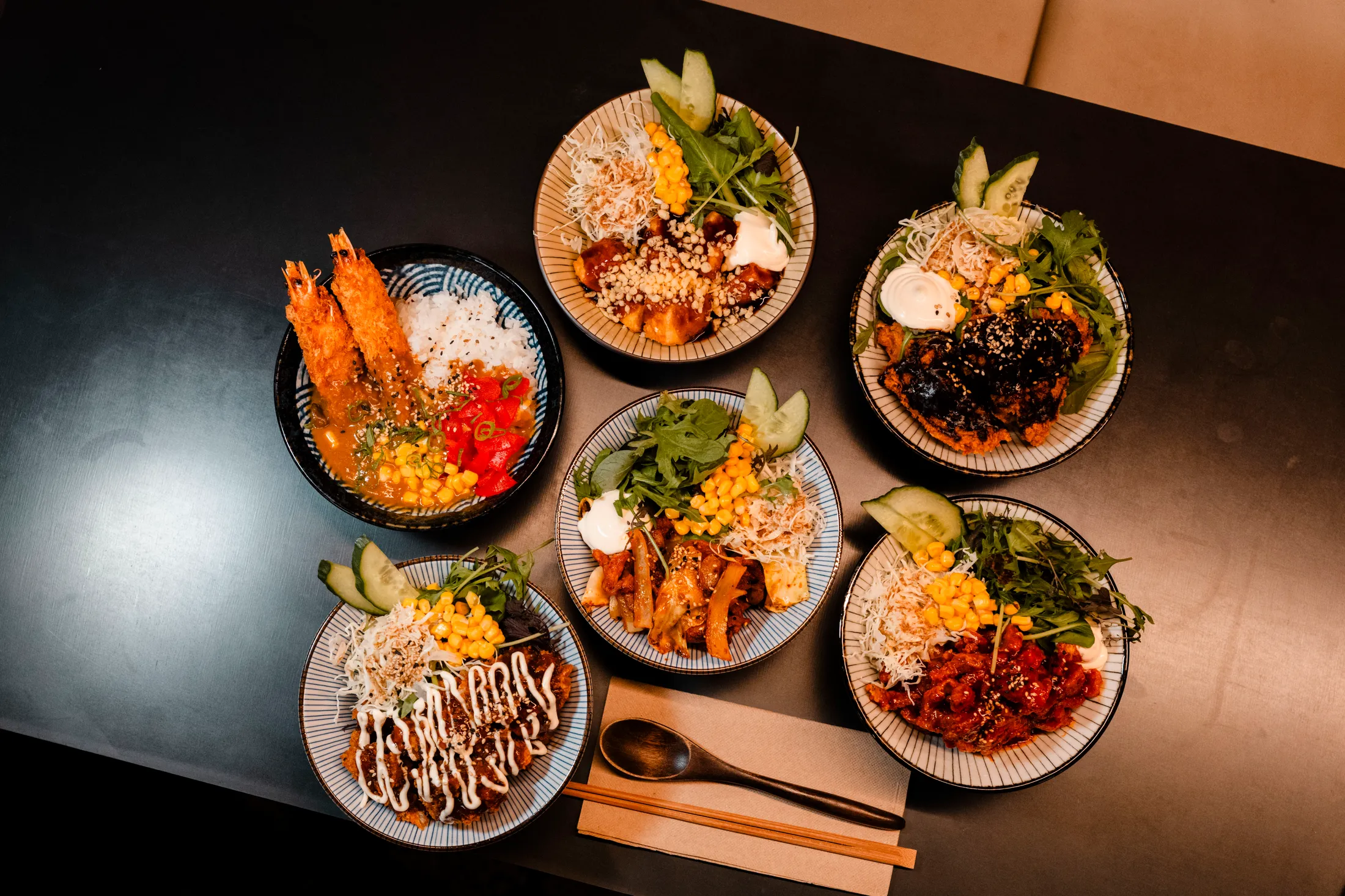 An overhead spread of WATDA Korean dishes and banchan